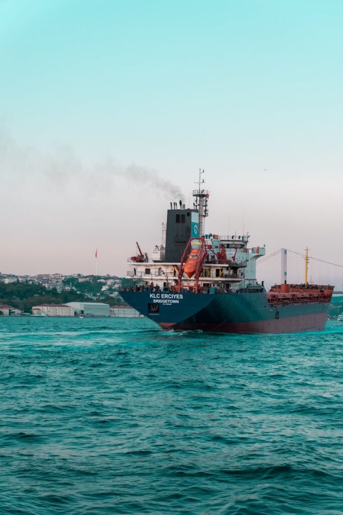 Cargo Ship on Sea Under Blue and White Sky